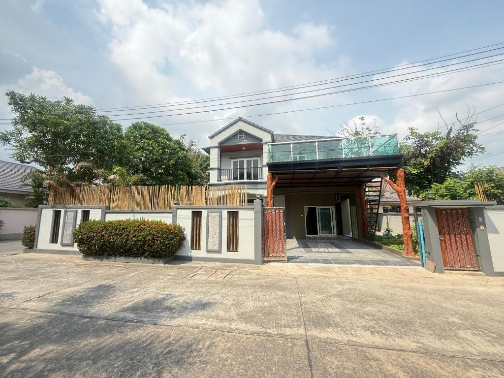 a house with a balcony on top of it at Sufficient House in Nong Prue