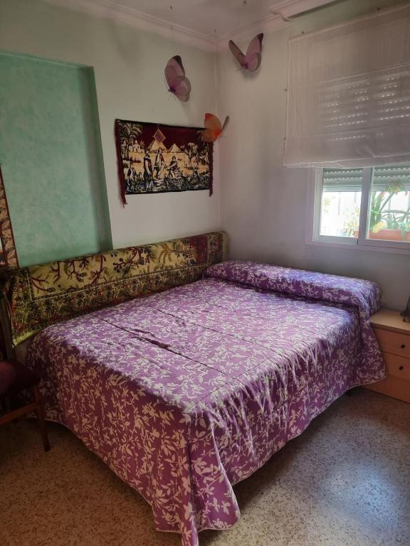 a bedroom with a bed with a purple bedspread at Apto Templo de Isis, Habitación Verde en Amate in Seville