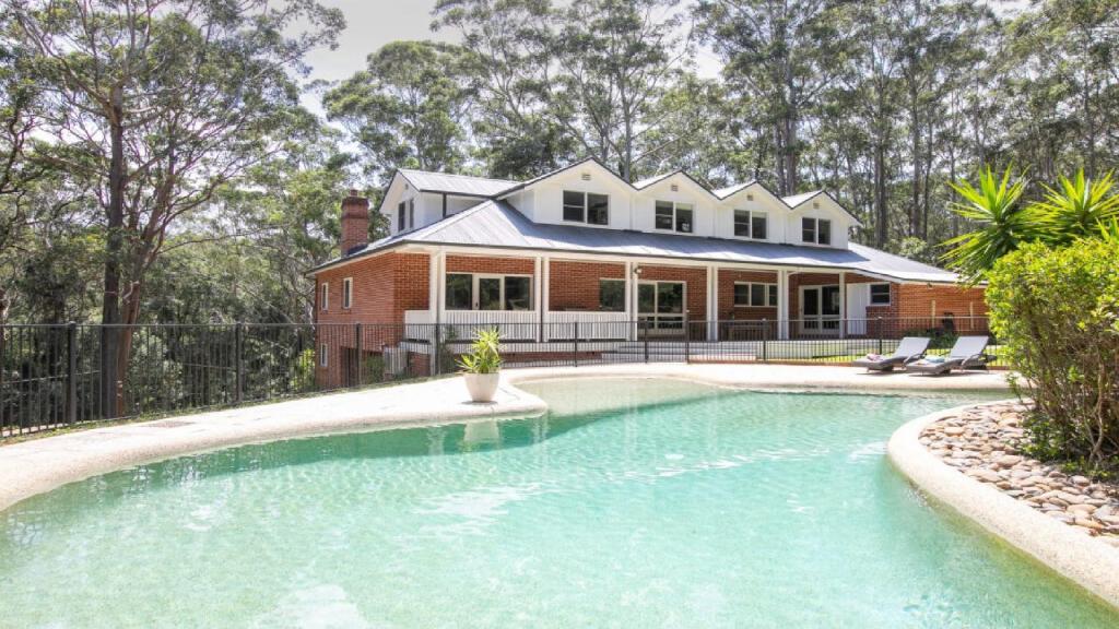 a house with a swimming pool in front of a house at Nirvana Estate Macmasters Beach in Macmasters Beach