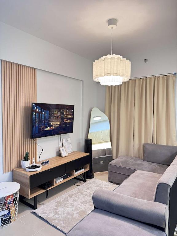 a living room with a couch and a flat screen tv at Alea Residences 1 Bedroom Condo with Pool View Balcony in Manila