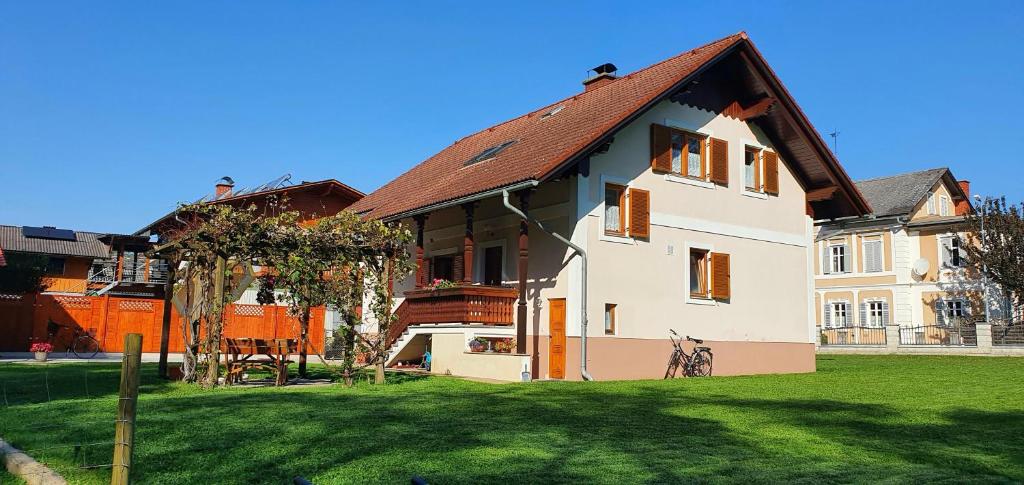 a white house with a brown roof on a green field at Haus an der Mur in Mureck