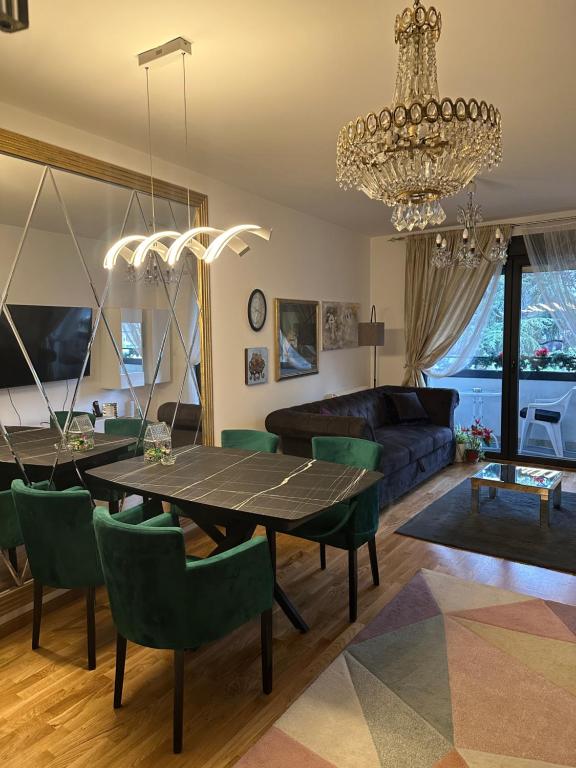 a living room with a table and green chairs at Lux Tea Pancevo in Pančevo