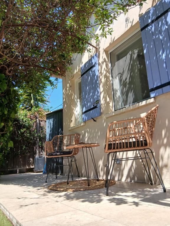 two chairs and a table in front of a house at Maisonnette zen - Parking Gratuit in Avignon