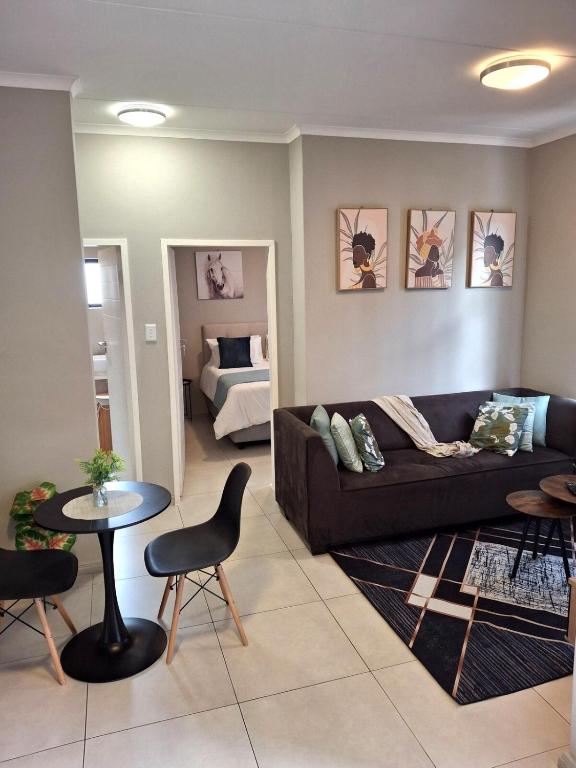 a living room with a couch and a table and a bed at Oak and Olive Retreat Midrand in Midrand