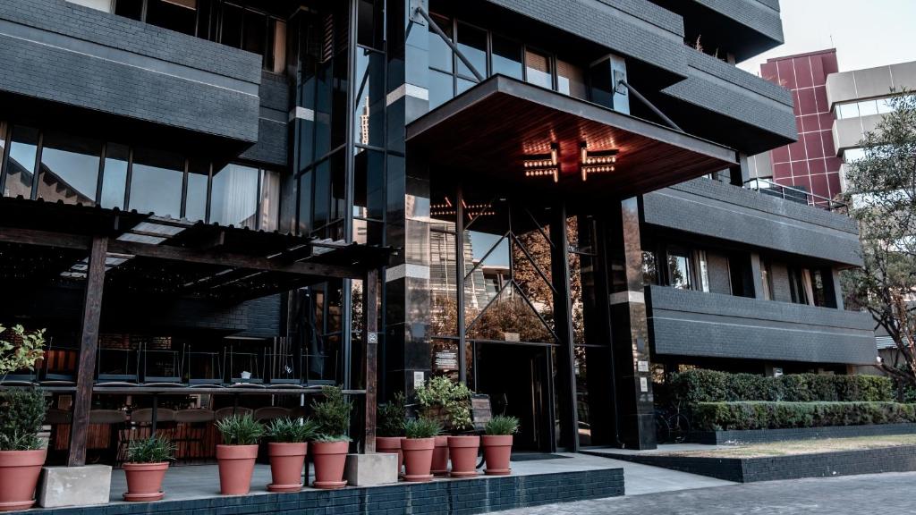 ein Gebäude mit Topfpflanzen davor in der Unterkunft BlackBrick Sandton One in Johannesburg