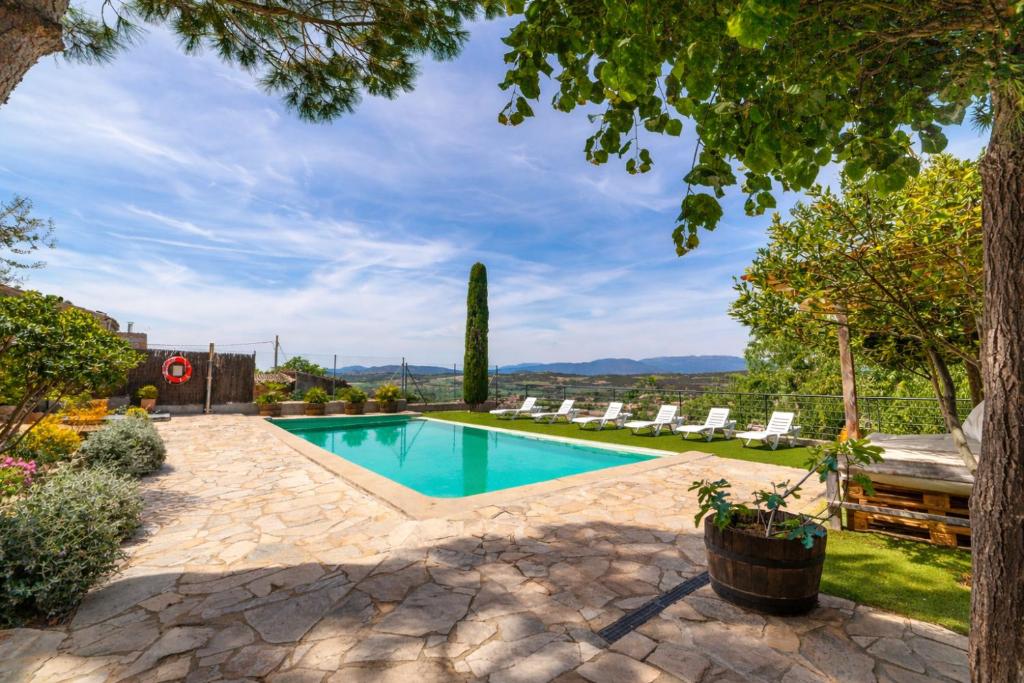 a swimming pool in a yard with chairs and trees at Cal París Rural in La Donzell D'Urgell
