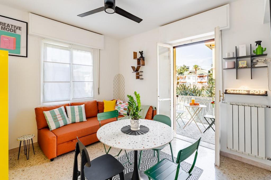 a living room with an orange couch and a table at La casetta POP in Bordighera