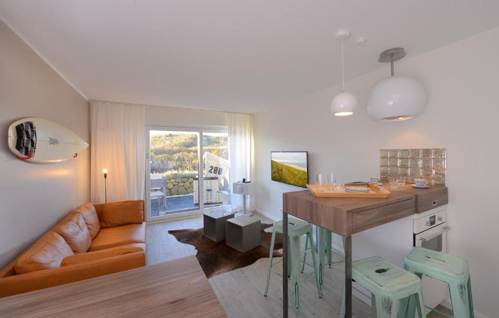ein Wohnzimmer mit einem Tisch und einem Sofa in der Unterkunft Wenningstedt Beach Apartment in Wenningstedt-Braderup