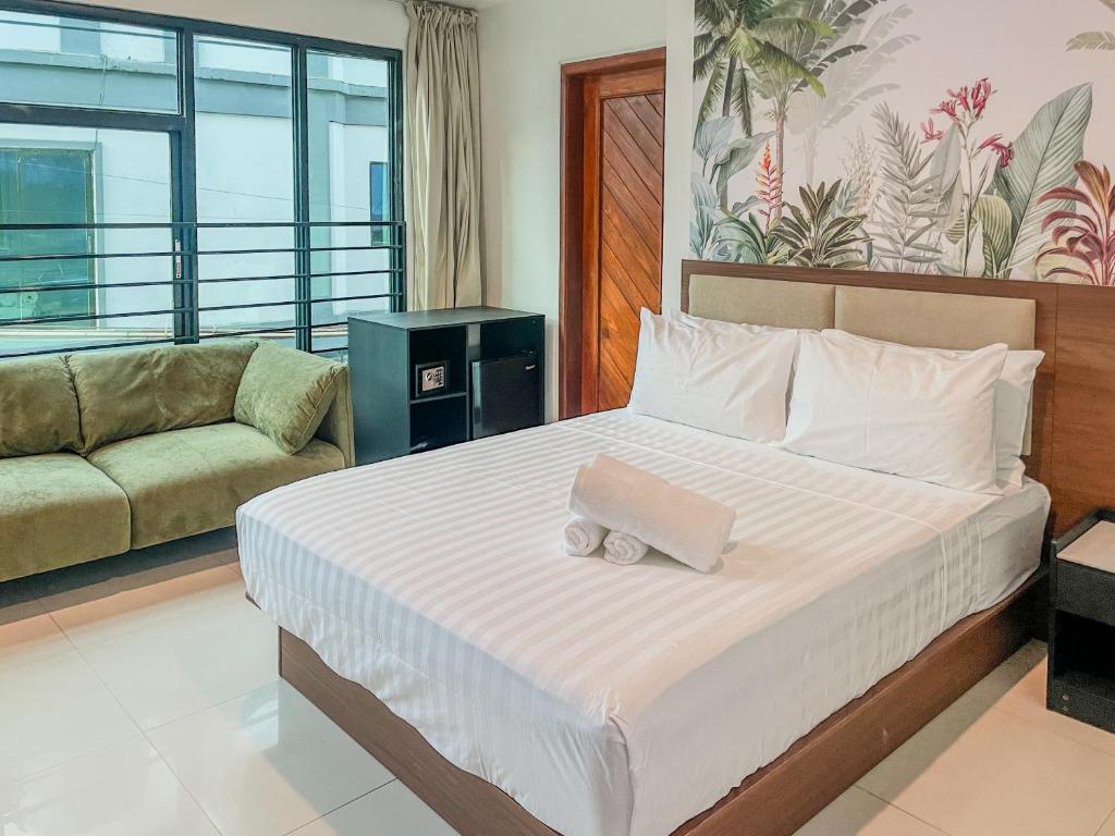 a bedroom with a bed and a couch at The Town - By Namal in El Nido