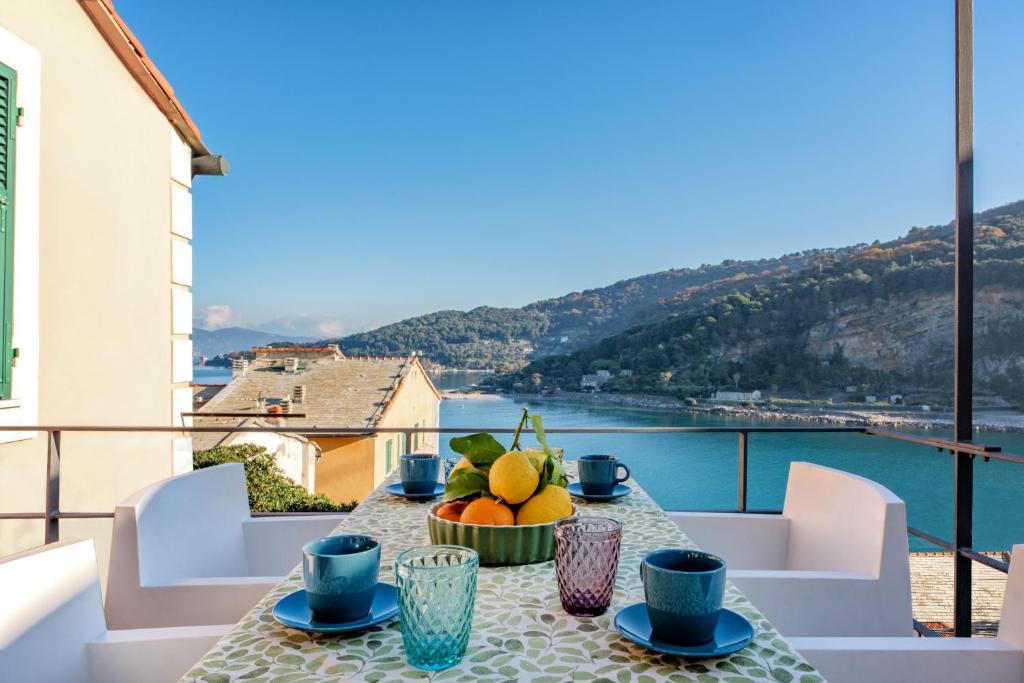 a table on a balcony with a view of the water at Casa Emily in Portovenere