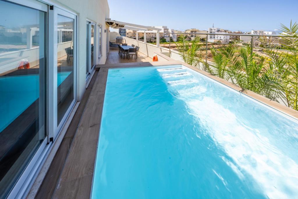 a swimming pool on the balcony of a house at Designer Luxury Penthouse with Private Pool & BBQ in Żurrieq