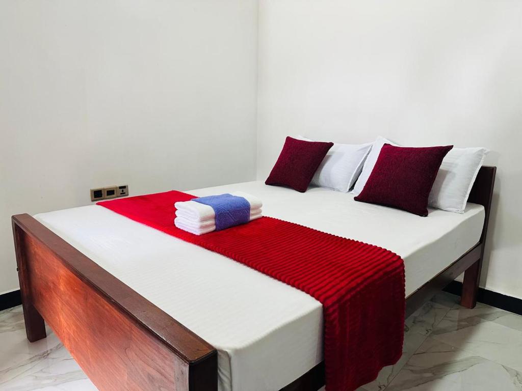 a bed with a red and white blanket on it at Yala Dream Wild Resort in Tissamaharama