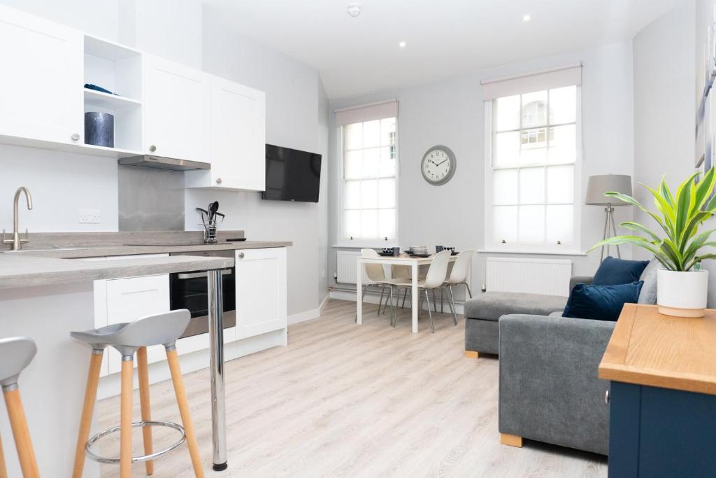 a kitchen and living room with a couch and a table at Spa Court in Cheltenham