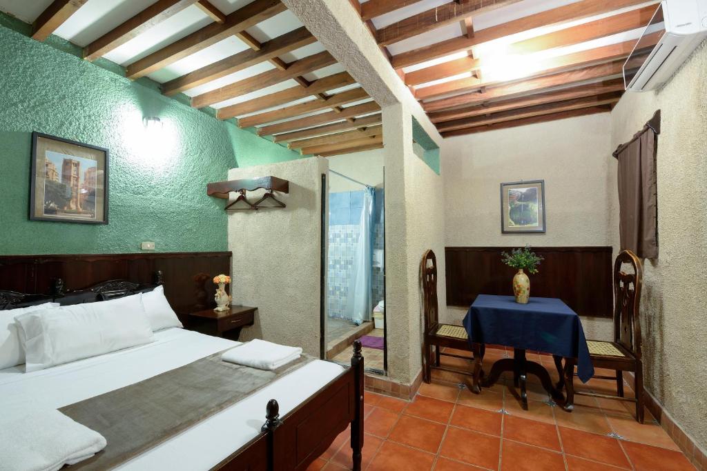 um quarto com uma cama, uma mesa e uma cadeira em Hotel Libano em León