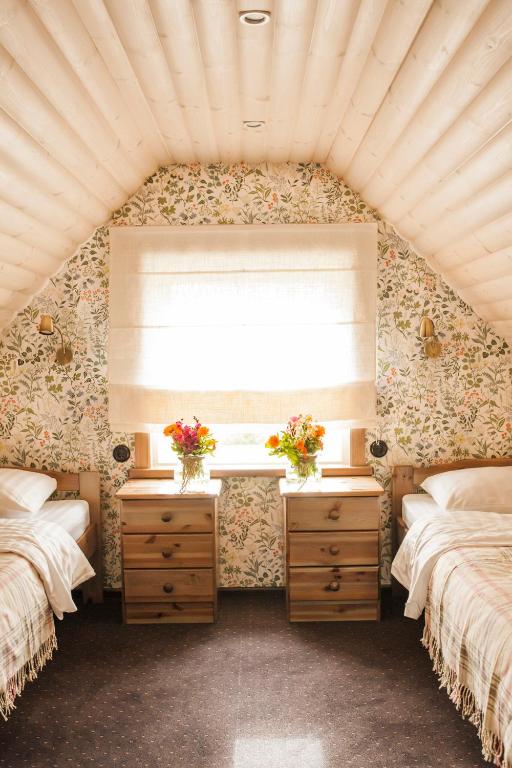 a bedroom with two twin beds and a window at Lammasmäe Puhkekeskus in Linnuse