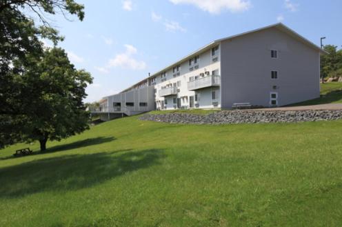 un grand bâtiment blanc avec une pelouse devant lui dans l'établissement Americas Best Value Inn - Duluth Spirit Mountain Inn, à Duluth