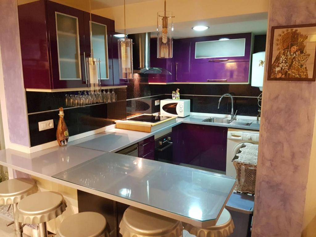 una cocina con armarios morados y una barra con taburetes en Balandra Flat, en Valencia