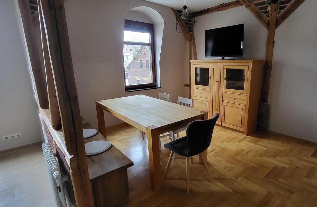 a dining room with a wooden table and a television at Appartment Paula in Heinsdorfergrund