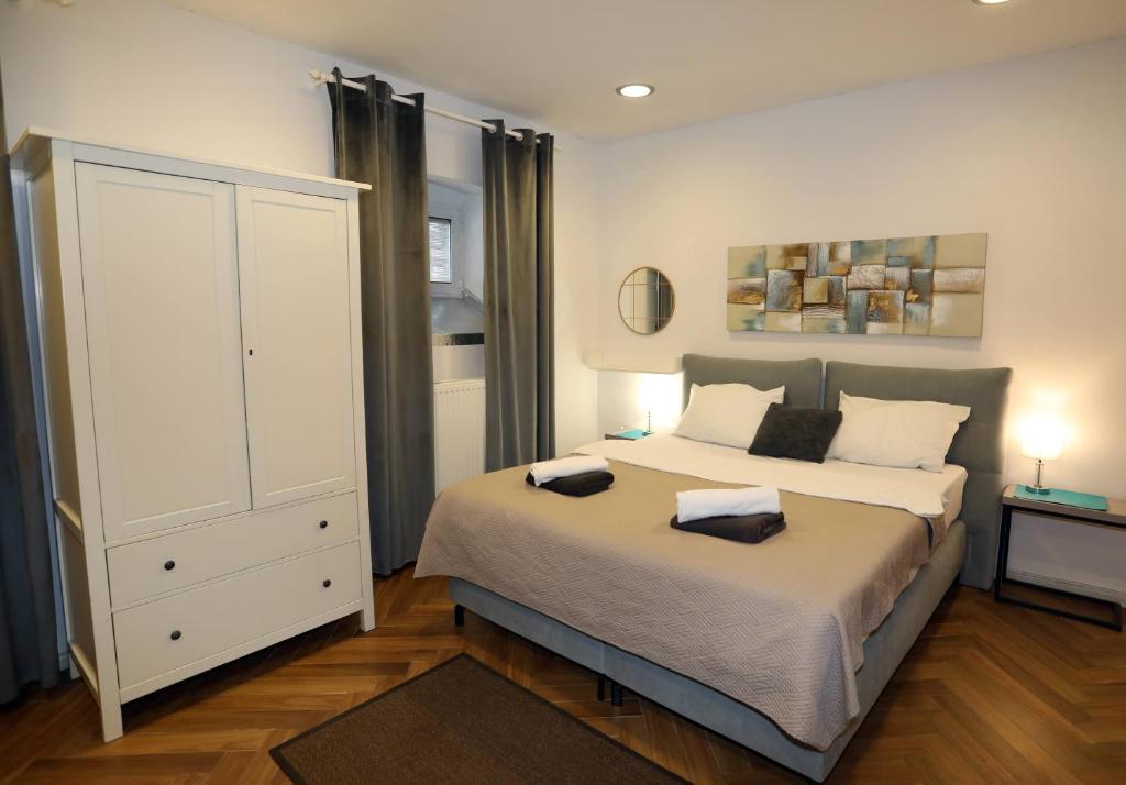 a bedroom with a large bed and a white cabinet at DJ Pula Studio - City Center in Pula