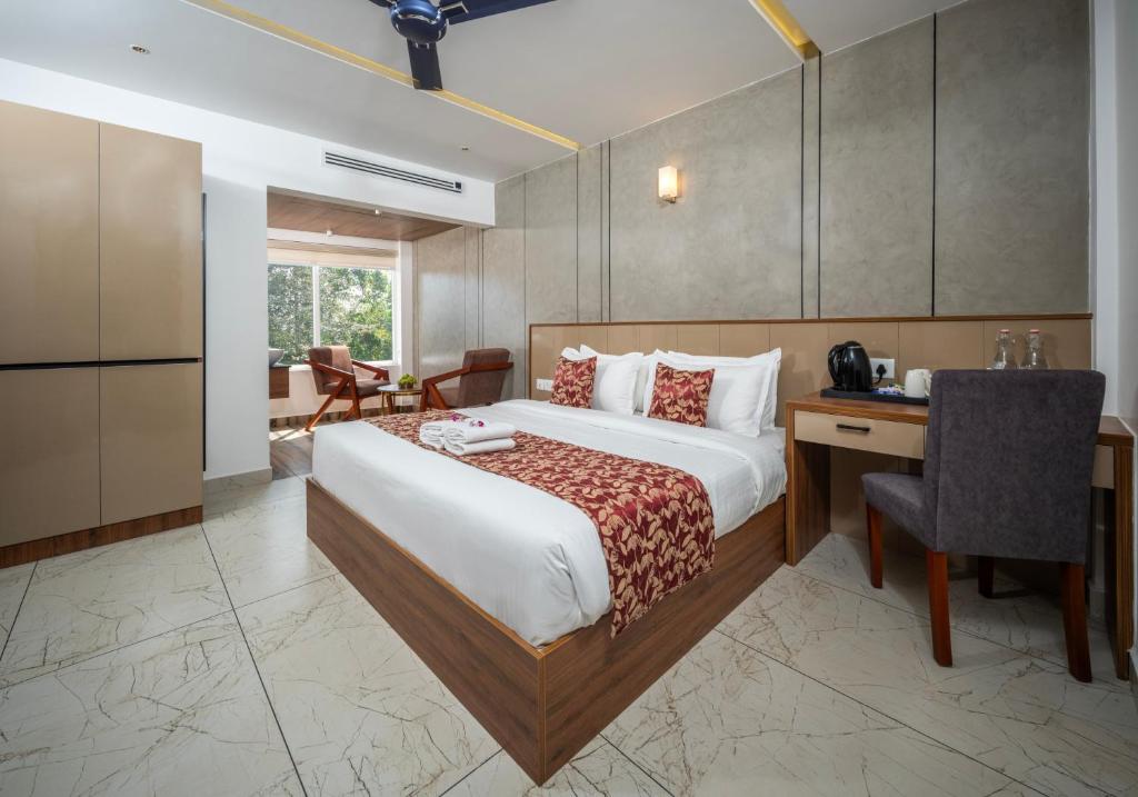 a hotel room with a bed and a desk and a chair at Boulevard Premium Luxury Hotel in Munnar