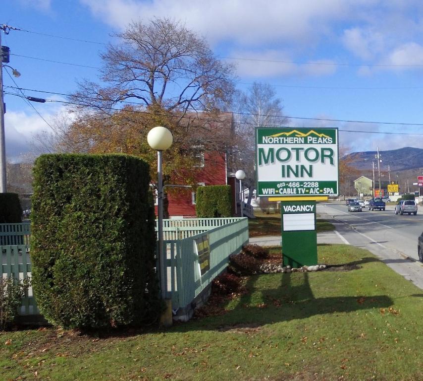 a sign for a motor inn on the side of a street at Northern Peaks Motor Inn in Gorham