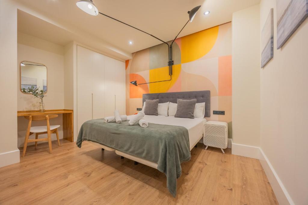 a bedroom with a bed and a colorful wall at BILBAO RIVERSIDE by STAYNN APARTMENTS in Bilbao