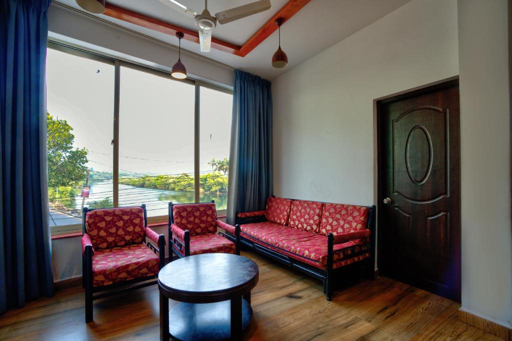 a waiting room with chairs and a table and a window at Baga Riverview 2BHK Mayonna Apartment in Baga