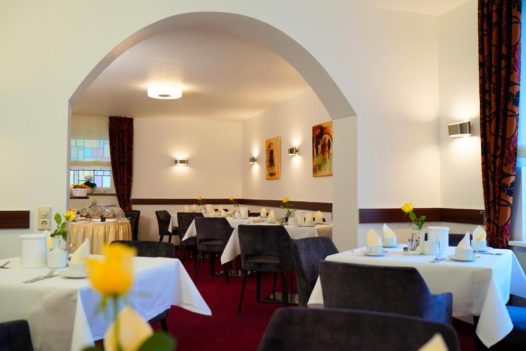 a dining room with tables and chairs and an archway at Haus Sparkuhl Hotel Garni in Hannover