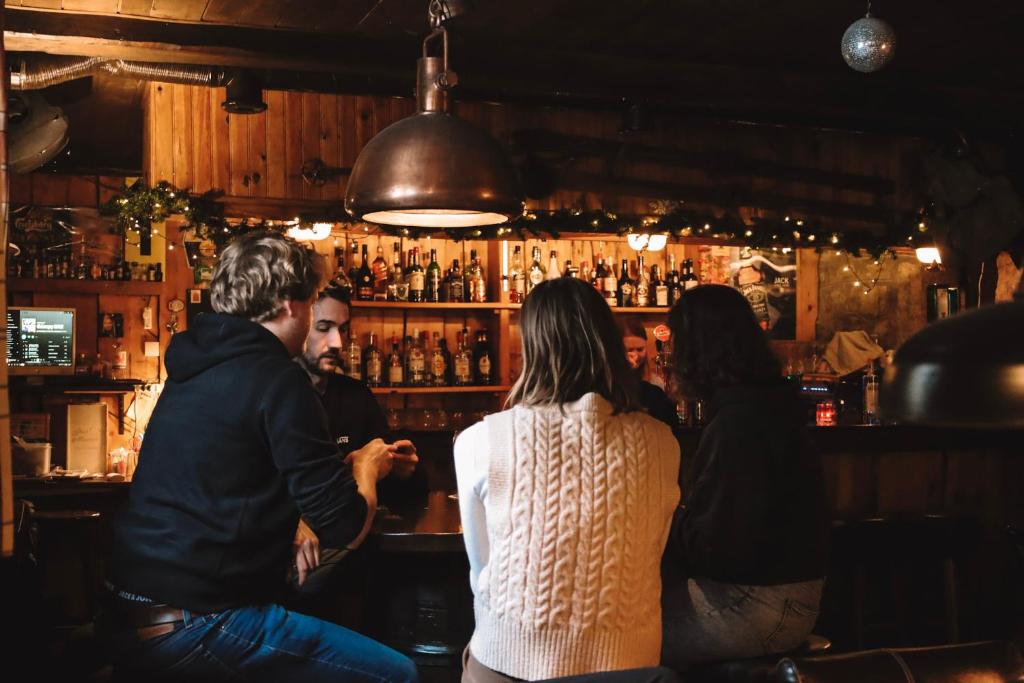 a group of people sitting at a bar at Hotel Le Genepy in Tignes