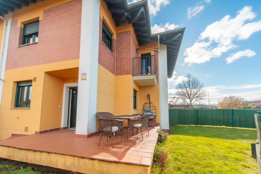 a house with a deck with a table and chairs at La Casa del Columpio, Comillas in Comillas