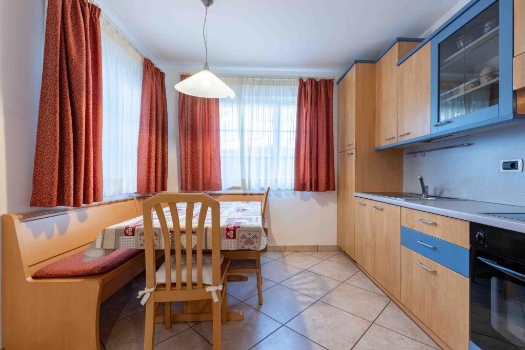 a kitchen with a table and a chair in it at Cesa Primula in Canazei