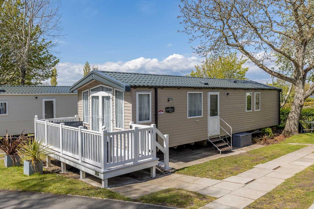 a tiny house with a porch and a deck at Hotel du Van - Rockley Park Caravan, Activities On-site in Poole