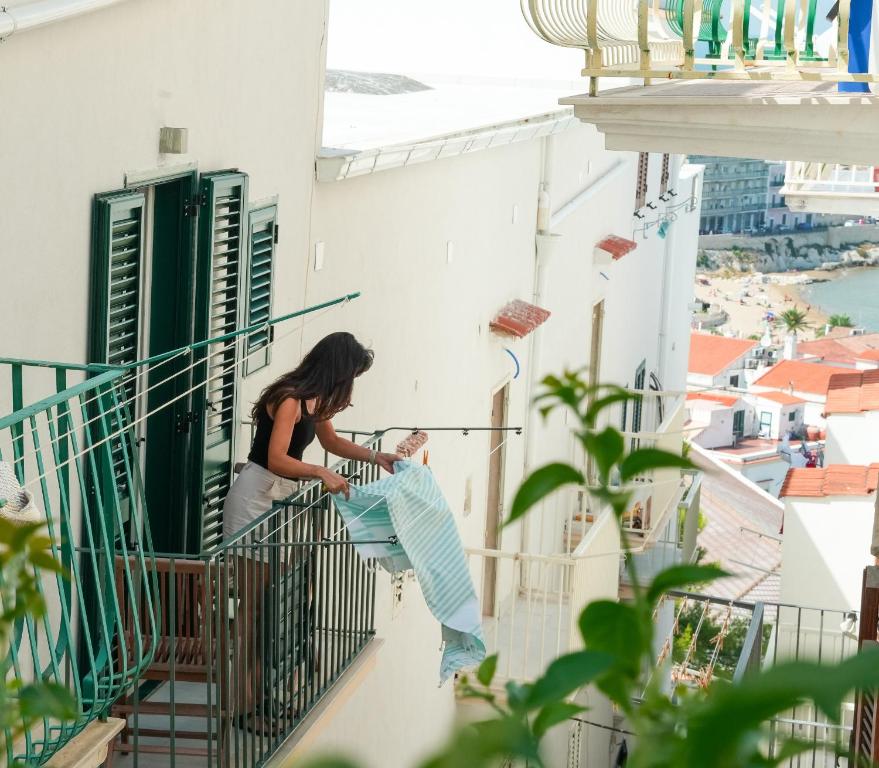 a woman standing on the balcony of a building at Casa Sveva in Vieste