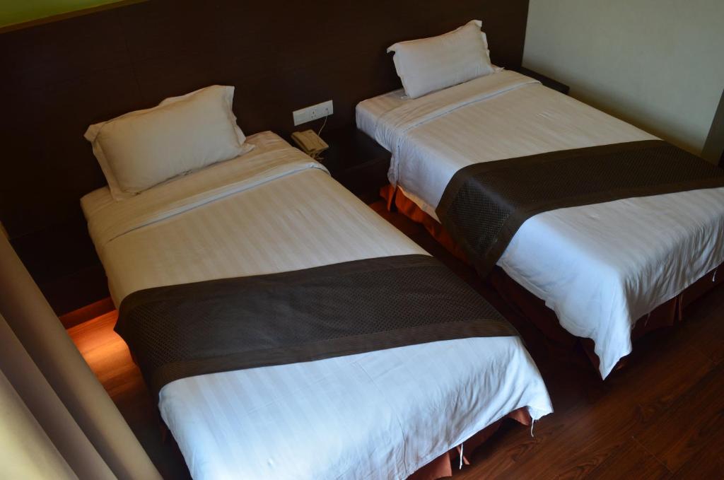 Postel nebo postele na pokoji v ubytování Lintas Plaza Hotel
