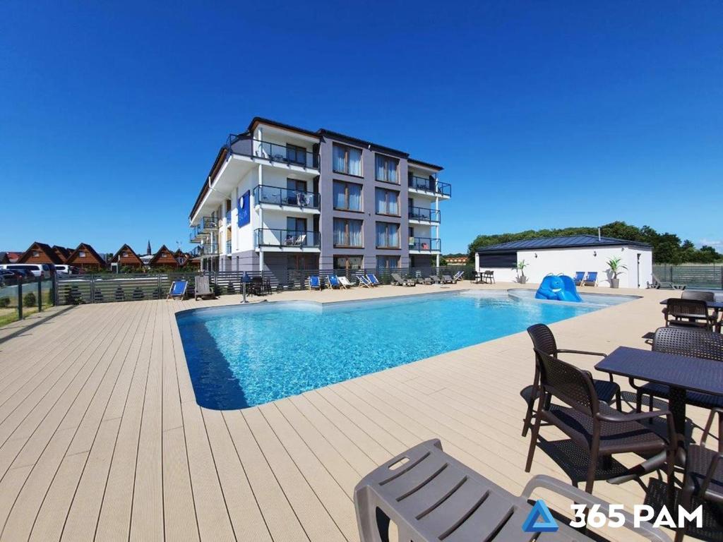a large apartment building with a swimming pool at 365PAM - Prywatne apartamenty w hotelu in Sarbinowo