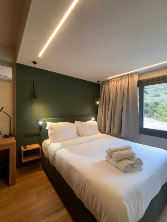 a bedroom with a large bed with towels on it at Montiva GuestHouse in Karpenisi