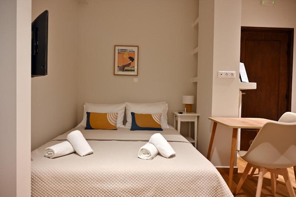 a bedroom with a bed with white sheets and pillows at Brand New! Fresh Kolonaki Studio in Athens