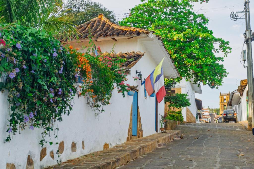 a white building with lots of flowers on it at El Principito Hospedaje in Barichara