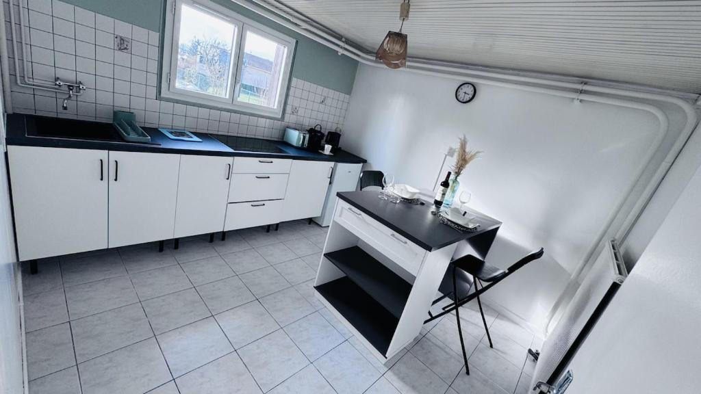 a kitchen with a sink and a table in it at Logement - maison d'hôtes Communay in Communay