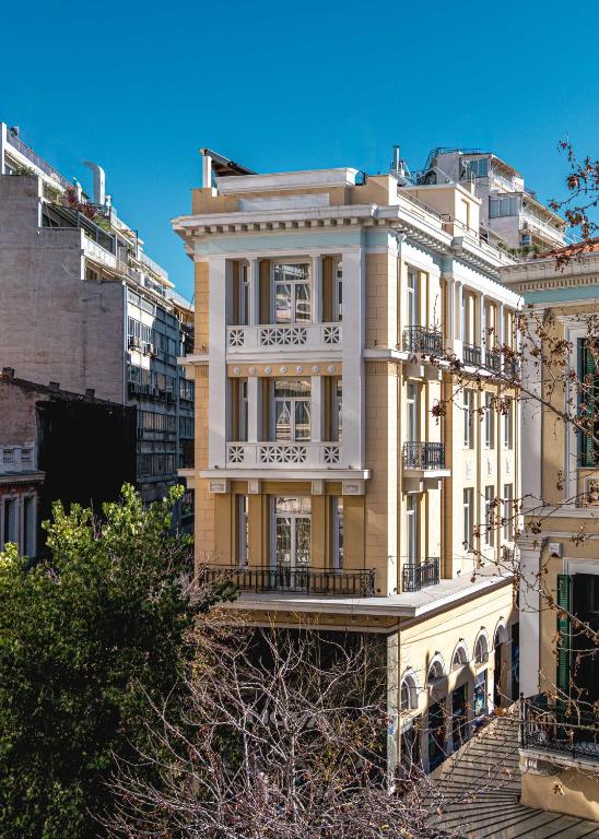 a white building with a balcony on a city street at EV 11 Athens in Athens
