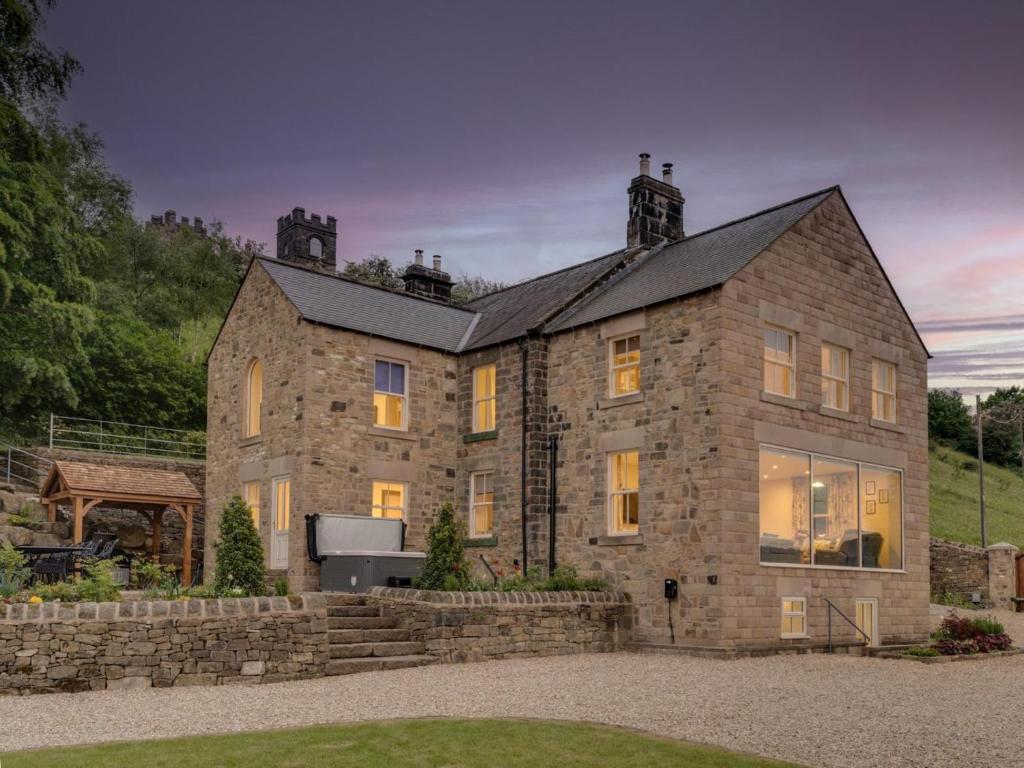 a large stone building with a clock tower on top at 7 Bed in Matlock oc-89448 in Matlock Bank