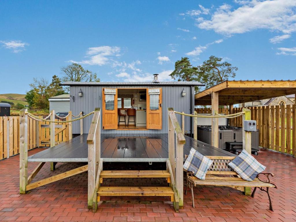 a tiny house on a patio with two benches at 1 Bed in Rhayader oc-90284 in Saint Harmon