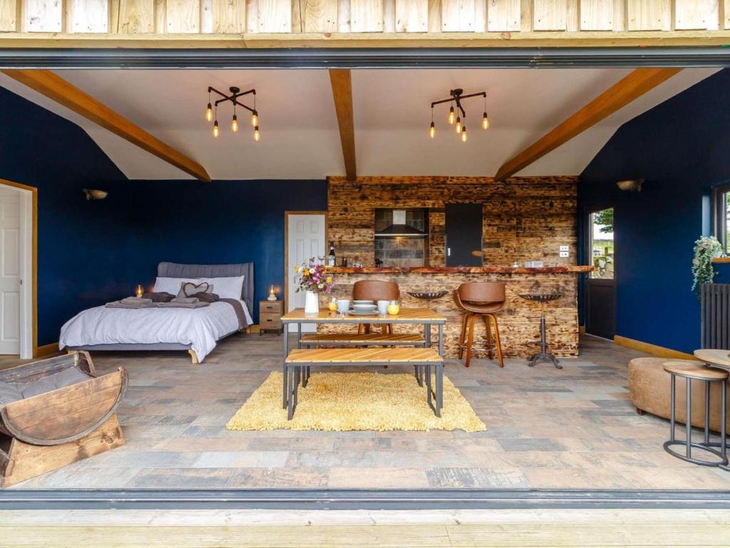 a bedroom with blue walls and a bed and a table at 1 Bed in Abergavenny oc-88015 in Llanover