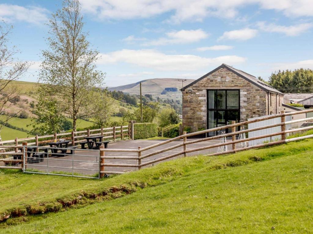 a barn conversion with a wooden fence and green grass at 2 Bed in Brecon oc-bn100 in Cray