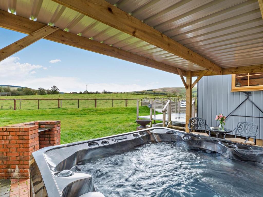 a hot tub on a patio with a roof at 1 Bed in Rhayader oc-90285 in Saint Harmon