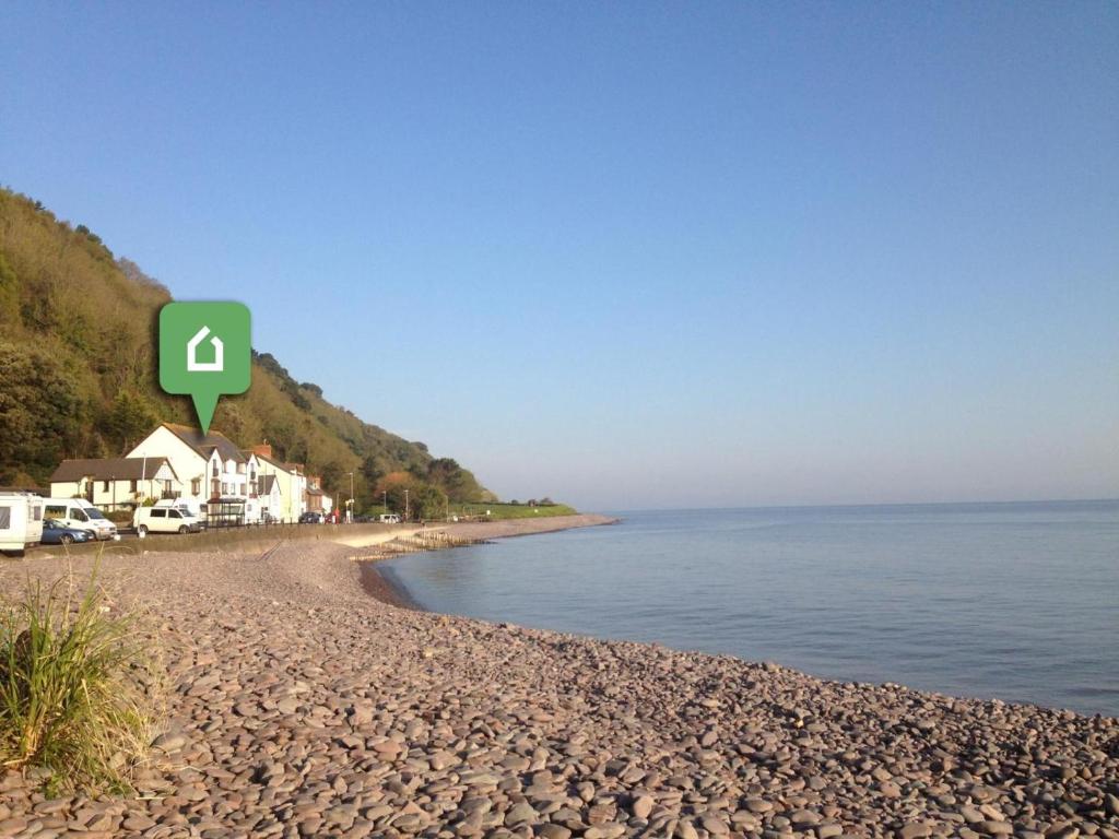 a beach with a green sign on it next to the water at 2 Bed in Minehead oc-75338 in Minehead