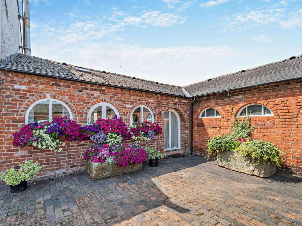 a brick building with potted plants and windows at 1 Bed in Derby oc-76518 in Tutbury