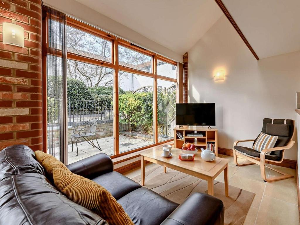 a living room with a leather couch and a tv at 1 Bed in Doncaster oc-91308 in Mattersey