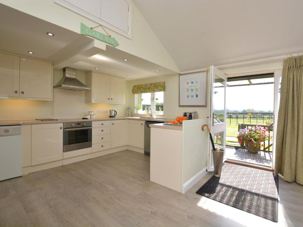 a kitchen with white cabinets and a large window at 2 Bed in Derby oc-76519 in Tutbury