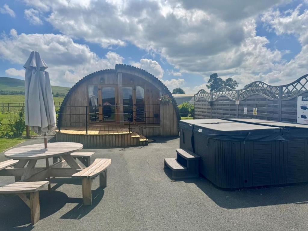 a wooden building with a picnic table and an umbrella at 2 Bed in Rhayader oc-90279 in Saint Harmon